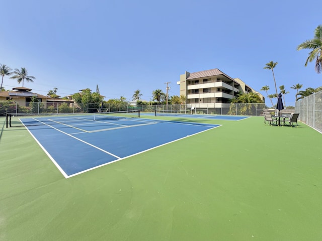 view of tennis court featuring fence and community basketball court