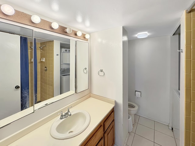 bathroom featuring toilet, stacked washer and dryer, tile patterned floors, vanity, and tiled shower