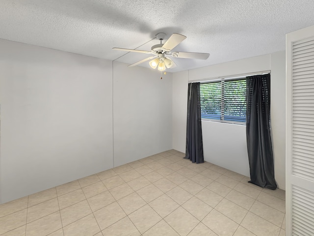 spare room featuring a ceiling fan and a textured ceiling