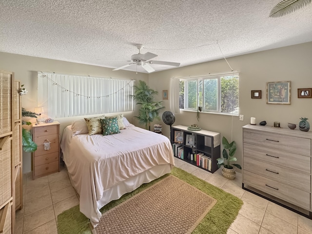 bedroom featuring light tile patterned floors, a ceiling fan, a textured ceiling, and visible vents