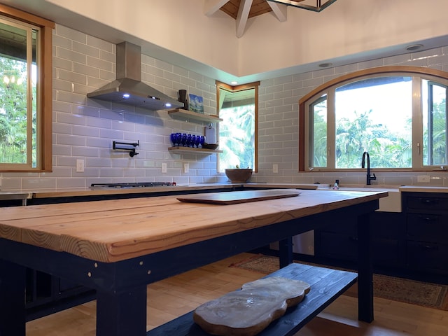 4631 Kahiliholo Rd, Kilauea, HI 96754 - kitchen with decorative backsplash, wall chimney exhaust hood, butcher block counters, and stainless steel gas cooktop