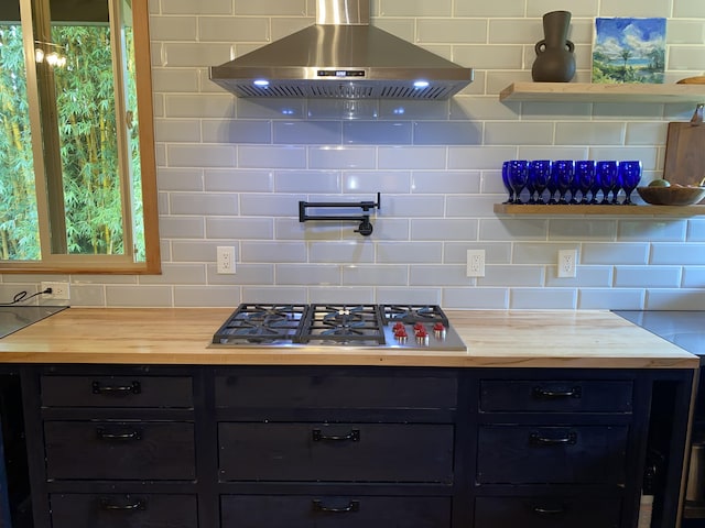 4631 Kahiliholo Rd, Kilauea, HI 96754 - kitchen with dark cabinets, decorative backsplash, stainless steel gas cooktop, and wall chimney range hood