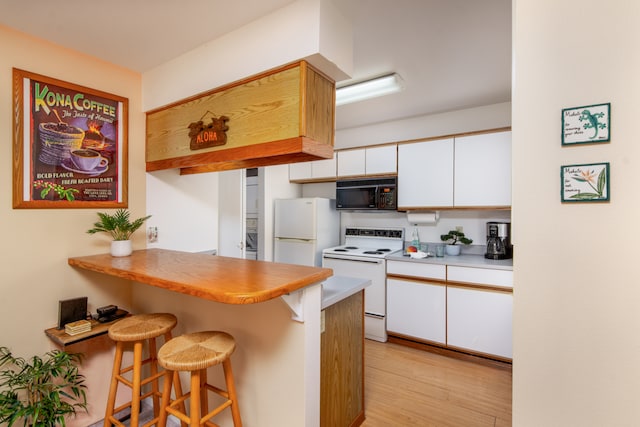 68-3831 Lua Kula St Unit G207, Waikoloa, HI 96738 - kitchen with white appliances, a kitchen breakfast bar, white cabinetry, light countertops, and a peninsula