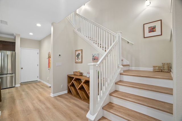 stairs featuring baseboards, wood finished floors, and recessed lighting