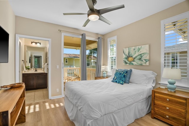 bedroom featuring ensuite bathroom, baseboards, access to outside, and light wood-style floors