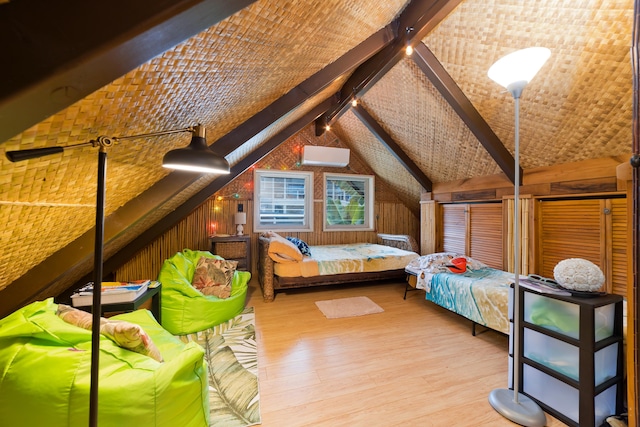 bedroom featuring wooden walls, a wall unit AC, vaulted ceiling with beams, and wood finished floors