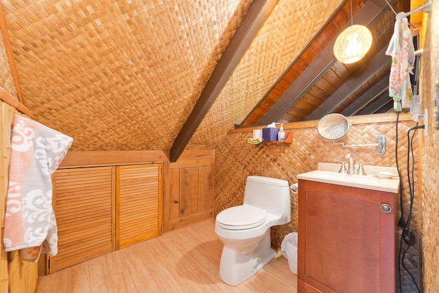 bathroom featuring beam ceiling, toilet, wood finished floors, and vanity