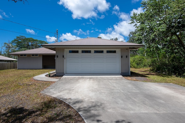 view of front of home with a front lawn, driveway, and metal roof