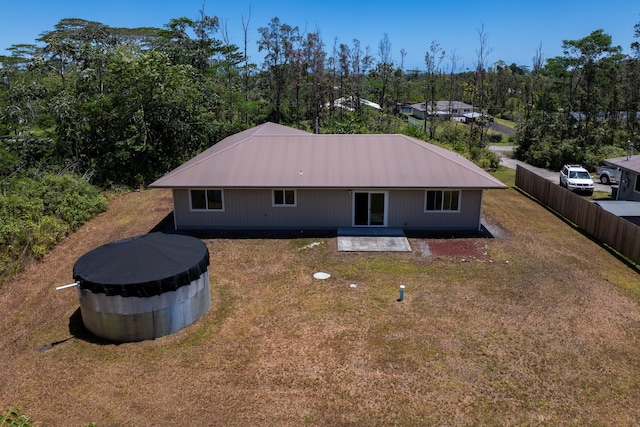 back of house with fence, a patio area, and a lawn