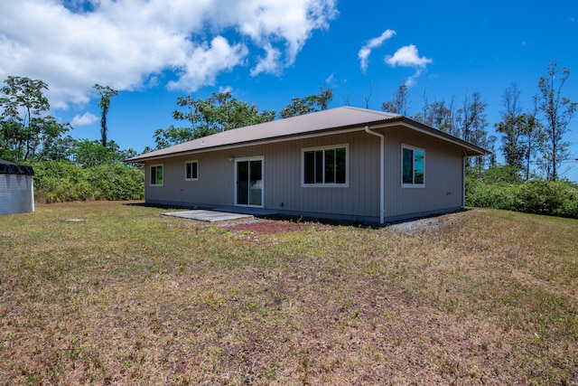 rear view of property featuring a lawn