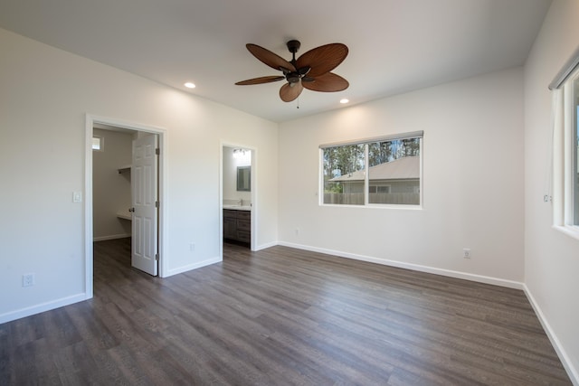 unfurnished bedroom featuring a spacious closet, dark wood-style flooring, and recessed lighting