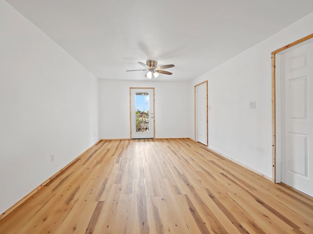 empty room with a ceiling fan and light wood-style floors