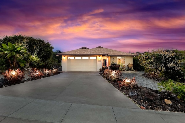ranch-style home with an attached garage, driveway, and stucco siding