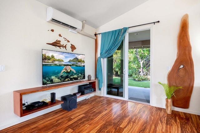 home theater room featuring a wall unit AC, wood finished floors, and lofted ceiling