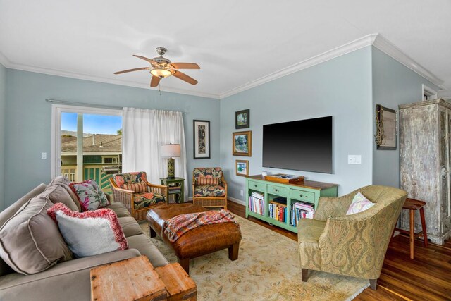 living area featuring a ceiling fan, crown molding, baseboards, and wood finished floors