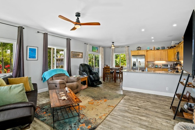 living area with a wealth of natural light, wood finished floors, recessed lighting, and a ceiling fan