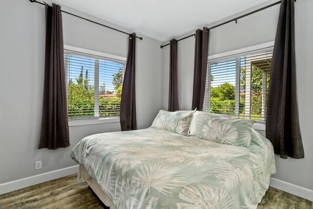 bedroom with baseboards and wood finished floors