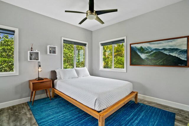 bedroom featuring baseboards, wood finished floors, and ceiling fan