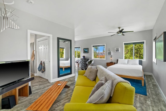 bedroom featuring baseboards, ceiling fan, wood finished floors, and access to outside