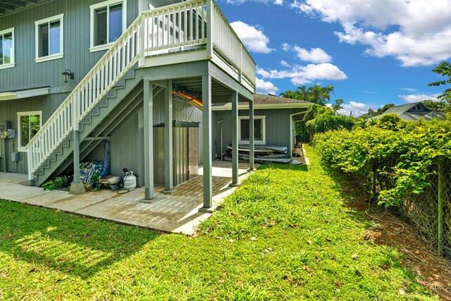 back of house with a lawn and stairway