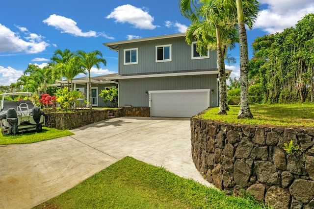 view of front of property featuring a front lawn, stone siding, an attached garage, and concrete driveway
