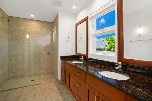 bathroom featuring double vanity, visible vents, a sink, and walk in shower
