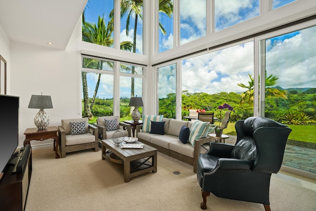 sunroom with carpet flooring, a towering ceiling, and recessed lighting