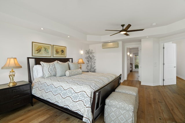 bedroom with a wall mounted AC, baseboards, ceiling fan, recessed lighting, and wood-type flooring