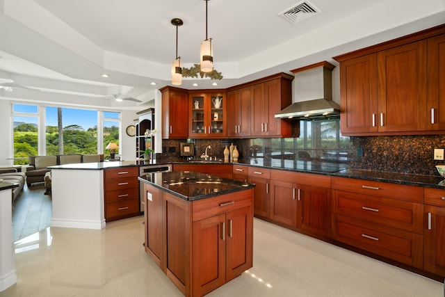 kitchen with black electric cooktop, visible vents, wall chimney exhaust hood, a sink, and a tray ceiling