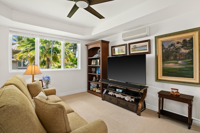 living area with a wall mounted air conditioner, baseboards, a ceiling fan, a tray ceiling, and light colored carpet
