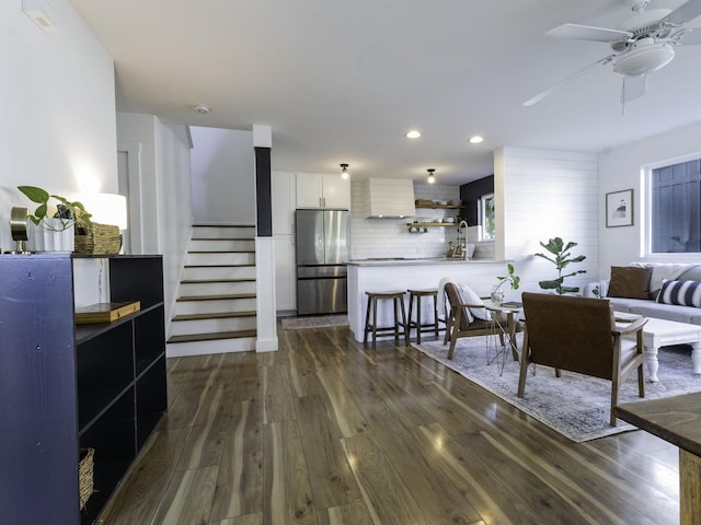living room with a ceiling fan, recessed lighting, stairs, and dark wood finished floors
