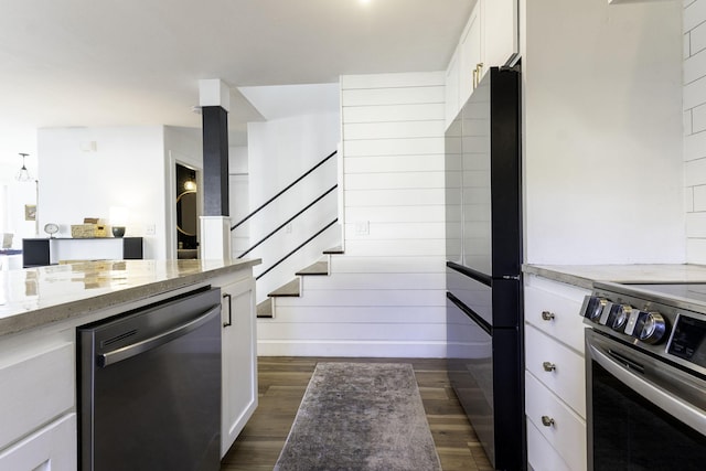 kitchen featuring dark wood finished floors, white cabinets, appliances with stainless steel finishes, and light stone counters