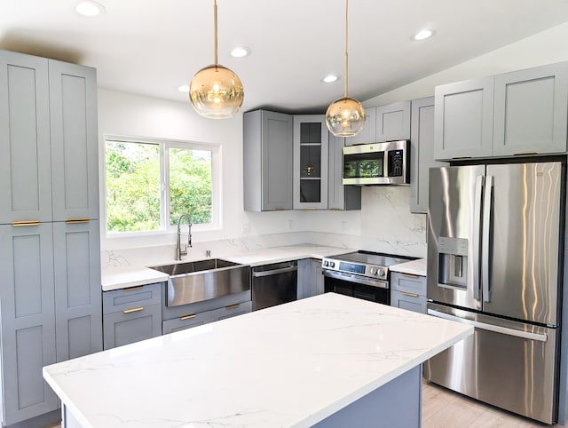 kitchen featuring appliances with stainless steel finishes, a sink, gray cabinetry, recessed lighting, and light stone counters