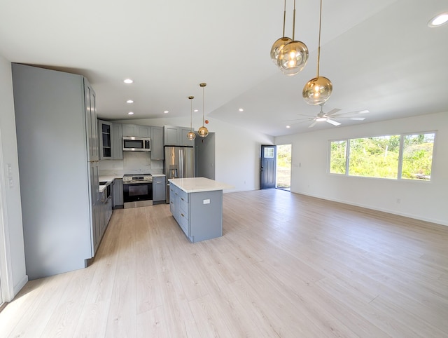 kitchen with appliances with stainless steel finishes, gray cabinets, light countertops, vaulted ceiling, and a ceiling fan