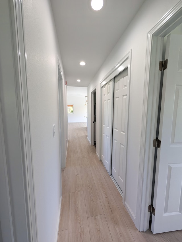 hallway with light wood-type flooring, recessed lighting, and baseboards