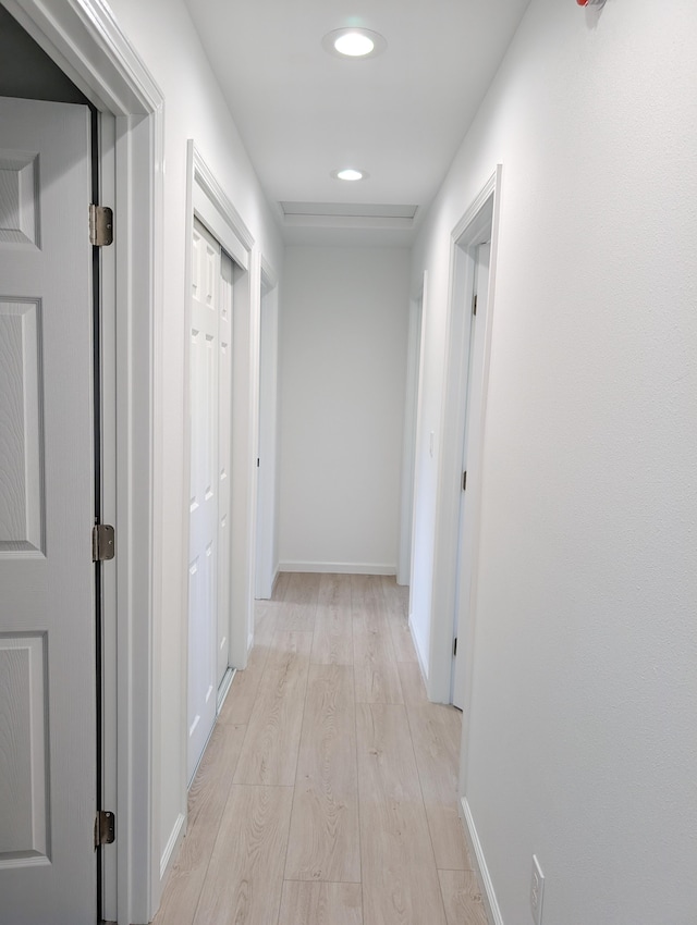 hall featuring light wood-style floors, recessed lighting, and baseboards