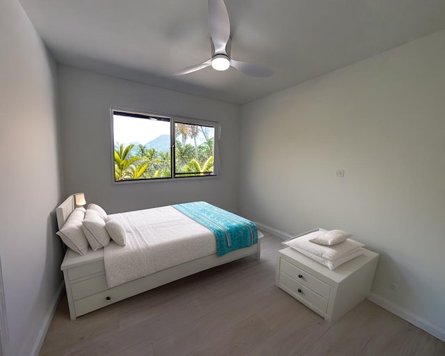 bedroom with baseboards, wood finished floors, and a ceiling fan