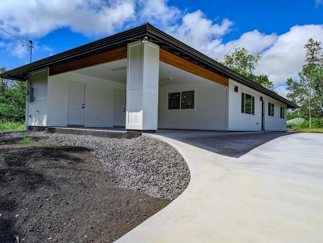rear view of property featuring concrete driveway