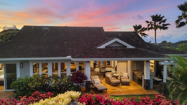 back of property featuring an outdoor living space, a patio, and exterior kitchen