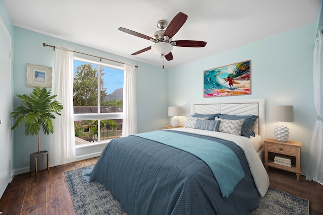 bedroom with wood finished floors, a ceiling fan, and baseboards