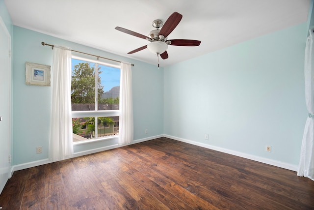 empty room with dark wood finished floors, ceiling fan, and baseboards