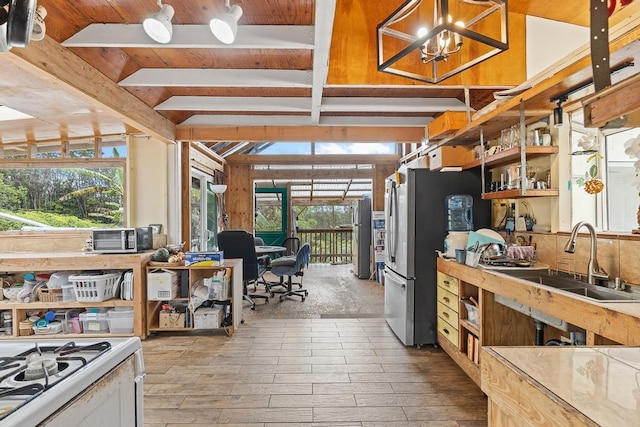 32-520 Piha Kahuku Rd, Ninole, HI 96773 - kitchen with a sink, freestanding refrigerator, wood finished floors, a chandelier, and white range with gas stovetop