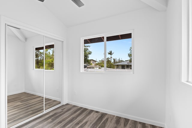 unfurnished bedroom with vaulted ceiling, dark wood finished floors, a closet, and baseboards