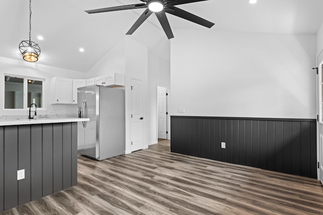 kitchen with stainless steel fridge with ice dispenser, light countertops, wood finished floors, white cabinets, and a ceiling fan