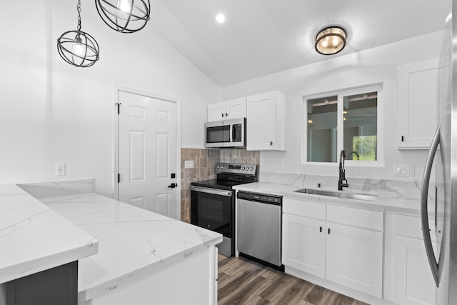 kitchen with stainless steel appliances, lofted ceiling, a sink, a peninsula, and white cabinets