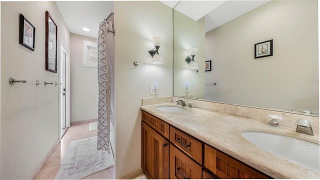bathroom with a shower with shower curtain, tile patterned floors, double vanity, and a sink