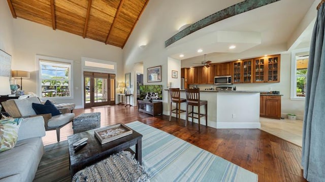 living room with a wealth of natural light, high vaulted ceiling, wooden ceiling, and hardwood / wood-style flooring