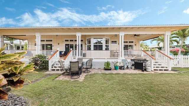 back of house with fence, covered porch, metal roof, and a lawn