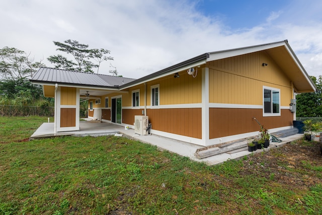 rear view of property with a ceiling fan, a patio, metal roof, and a cooling unit