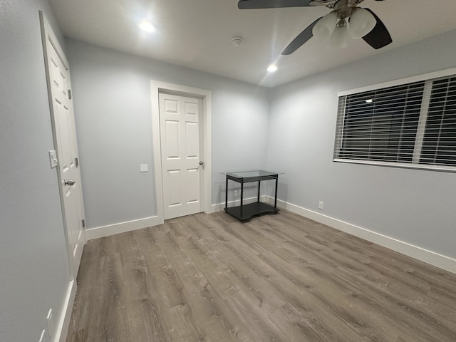 spare room with wood finished floors, recessed lighting, a ceiling fan, and baseboards